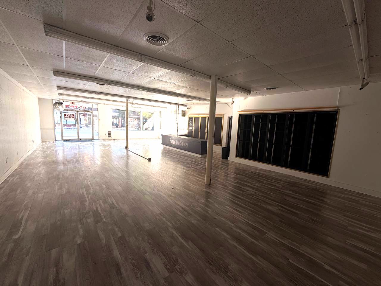 Open retail floor with new plank flooring and storefront windows